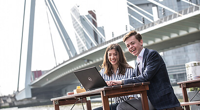 Students sitting in front of Erasmus bridge