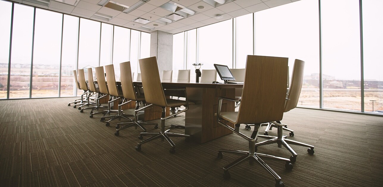 An empty table with empty seats in a boardroom
